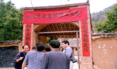 Officials and a TV station were on hand to celebrate the start of the Guanlan Scholarship in 2000, here entering the village primary school gate.